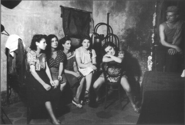 Interno di una casa di tolleranza a Napoli nel 1945. Il 29 gennaio 1958 venne approvata alla Camera la legge, presentata da Lina Merlin, che stabiliva la chiusura delle case di tolleranza in Italia. La legge entrò in vigore a marzo e impose che alla mezzanotte del 20 settembre 1958 venissero chiuse oltre 560 case di tolleranza distribuite su tutto il territorio nazionale.