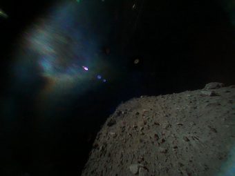 Foto a colori scattata dal Rover-1B alle 6:07 ora italiana di venerdì 21 settembre, immediatamente dopo la separazione dalla sonda madre Hayabusa-2. La superficie di Ryugu è in basso a destra. La chiazza colorata in alto a sinistra è dovuta al riflesso della luce solare. Crediti: Jaxa