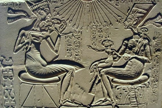 Il faraone Akhenaton (a sinistra) con la moglie Nefertiti e i figli al cospetto di Aton, il disco solare al centro del primo probabile culto monoteista. © Wikipedia
