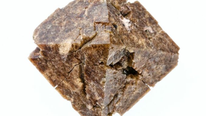 closeup of sample of natural mineral from geological collection - rough Zircon crystal isolated on white background