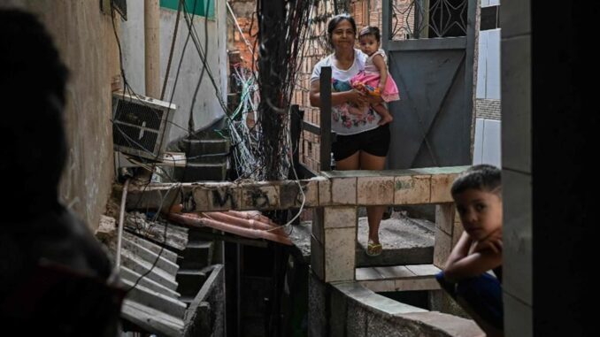 Una donna con i suoi figli all’interno della favela Rocinha di Rio de Janeiro, in Brasile: l’impennata dei livelli del debito provoca nei Paesi in via di sviluppo la riduzione degli investimenti produttivi nei settori pubblico e privato